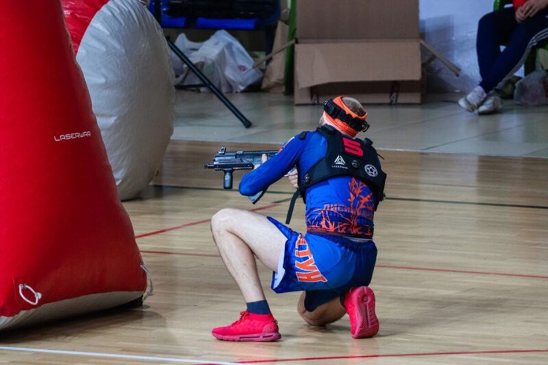 Игрок LASERWAR в низкой стойке с оружием наготове.